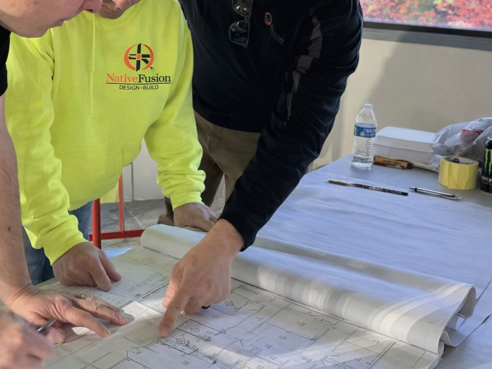 Team of architects and engineers reviewing and discussing building blueprints.