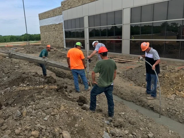 Construction worker wearing safety gear while working on a building site.